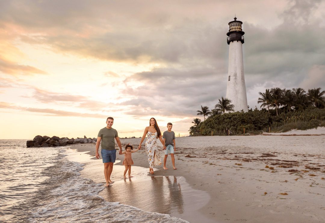 Family walking on the beach during a sunset photo session by best Miami family photographer Meli B
