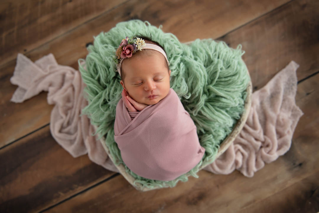 Swaddled baby girl in heart basket by South Florida Newborn Photographer
