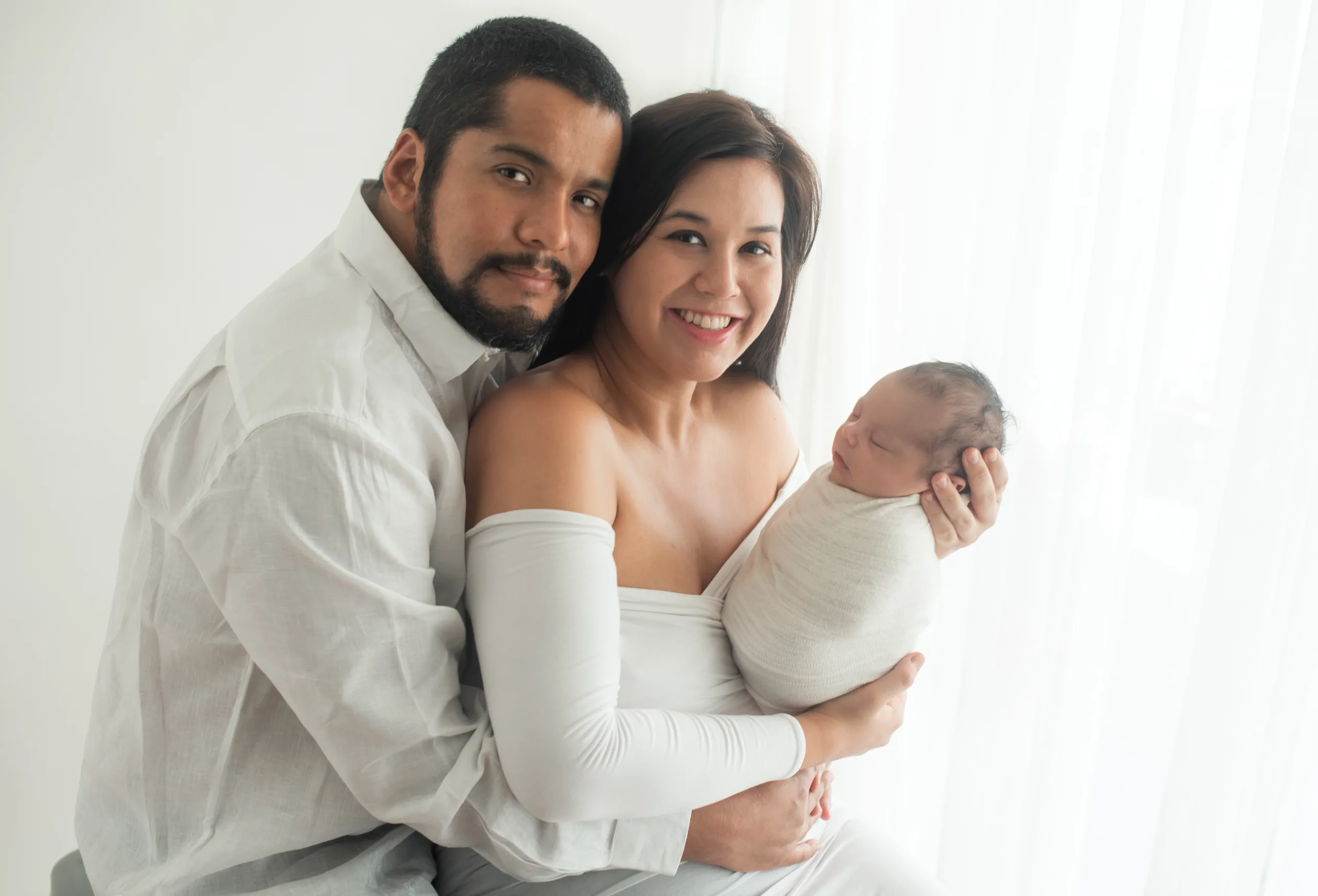 mom and dad holding newborn baby